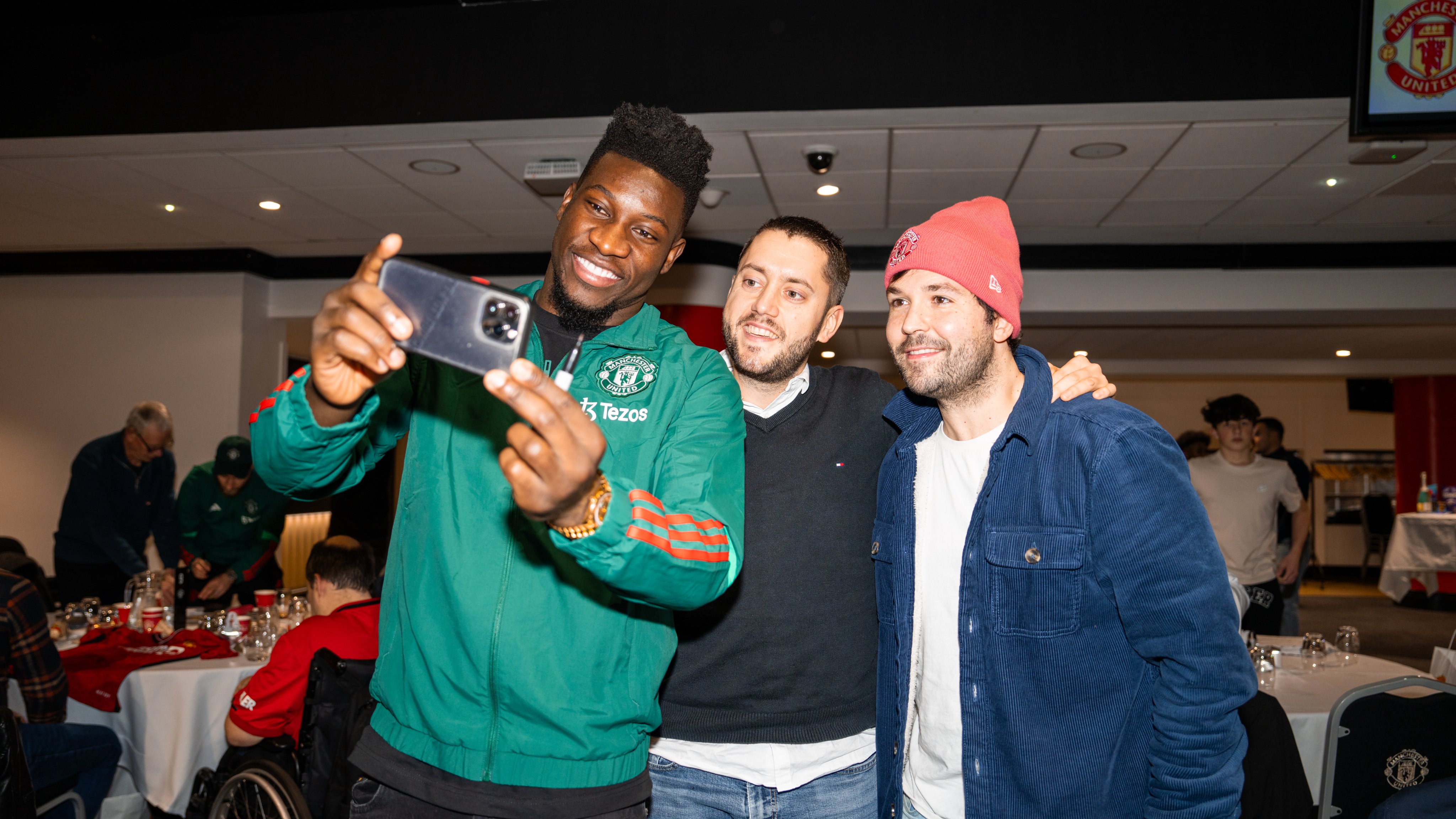 Andre Onana takes a selfie with two fans at the MUDSA Christmas party.